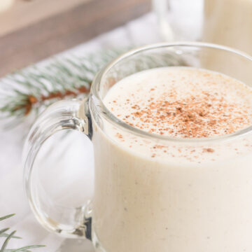 Homemade Egg Nog- egg nog in a clear mug garnished with nutmeg