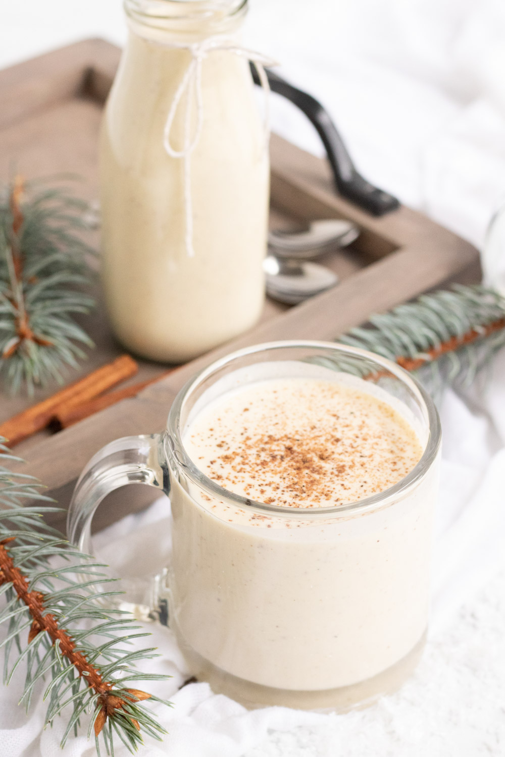 Egg Nog Recipe, a glass of homemade egg nog in a clear mug 