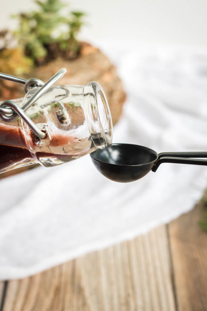 Elderberry Syrup Recipe, syrup being poured into a teaspoon