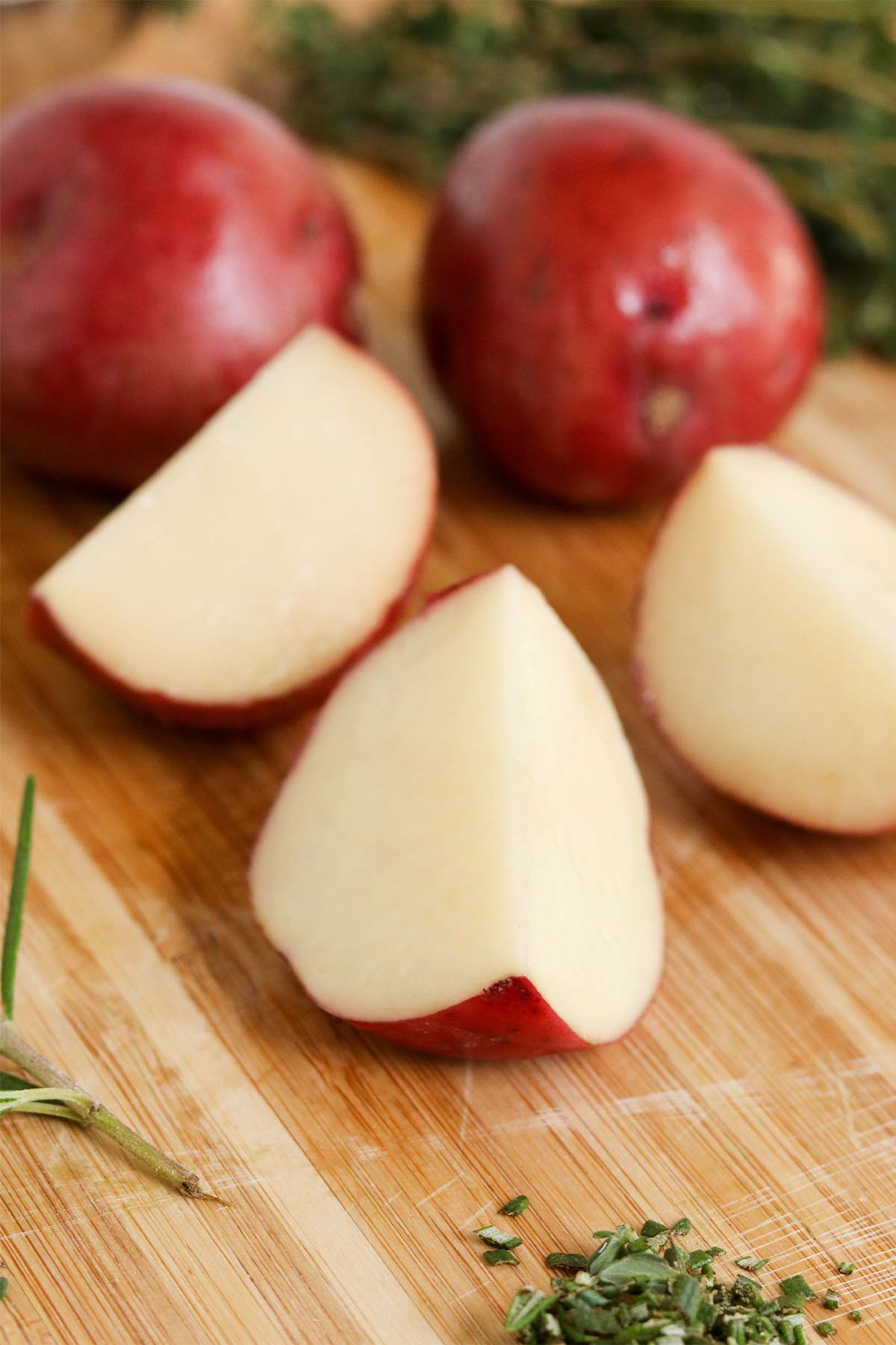 Red potatoes cut on a cutting board.