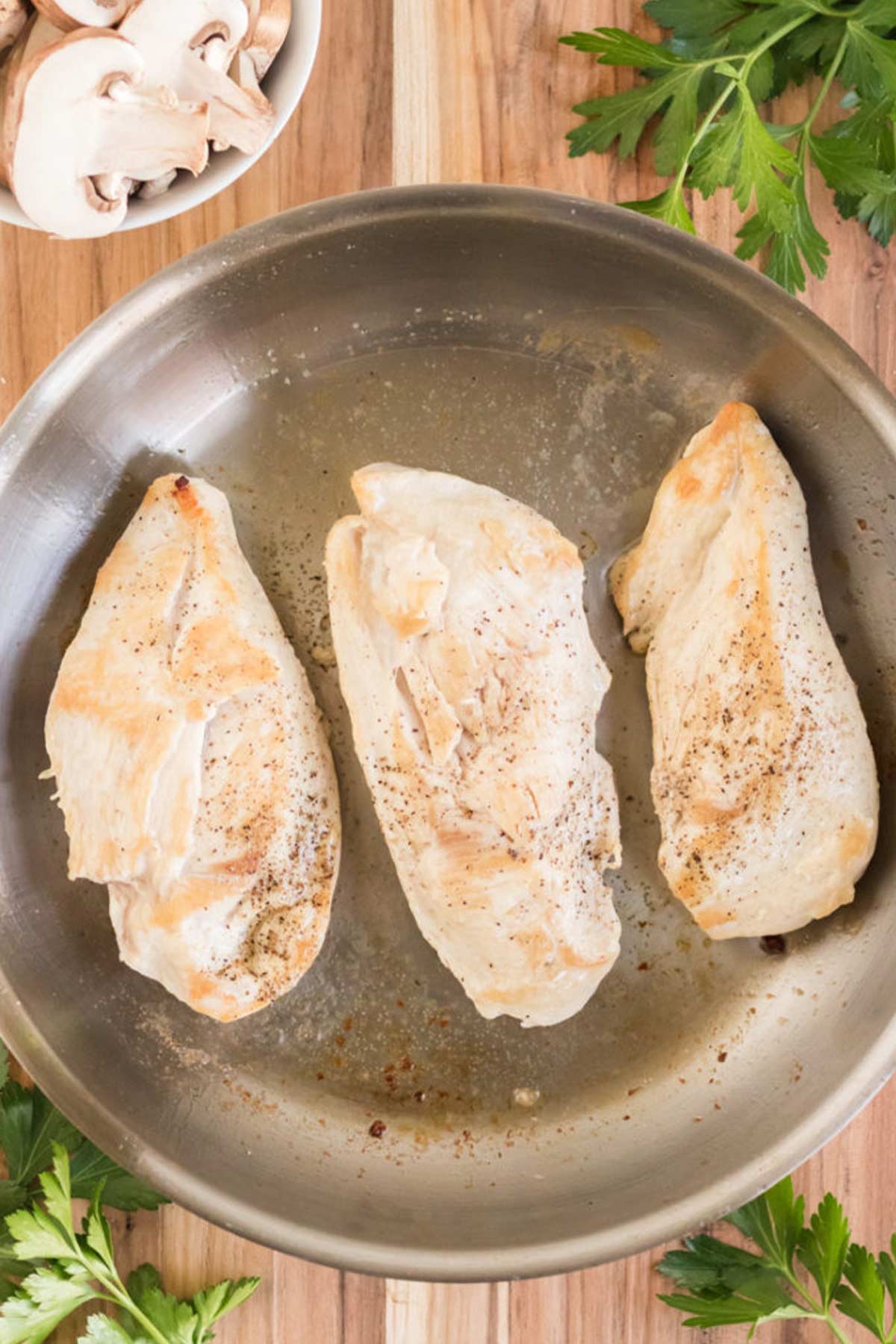 Chicken breasts are first cooked in a pan when making Champagne chicken.