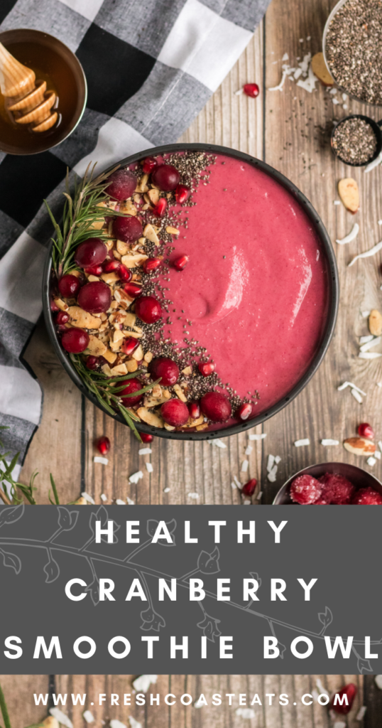 Pinterest image for cranberry smoothie bowl. There is a cranberry smoothie in a black bowl with almonds, chia and cranberries as garnish.