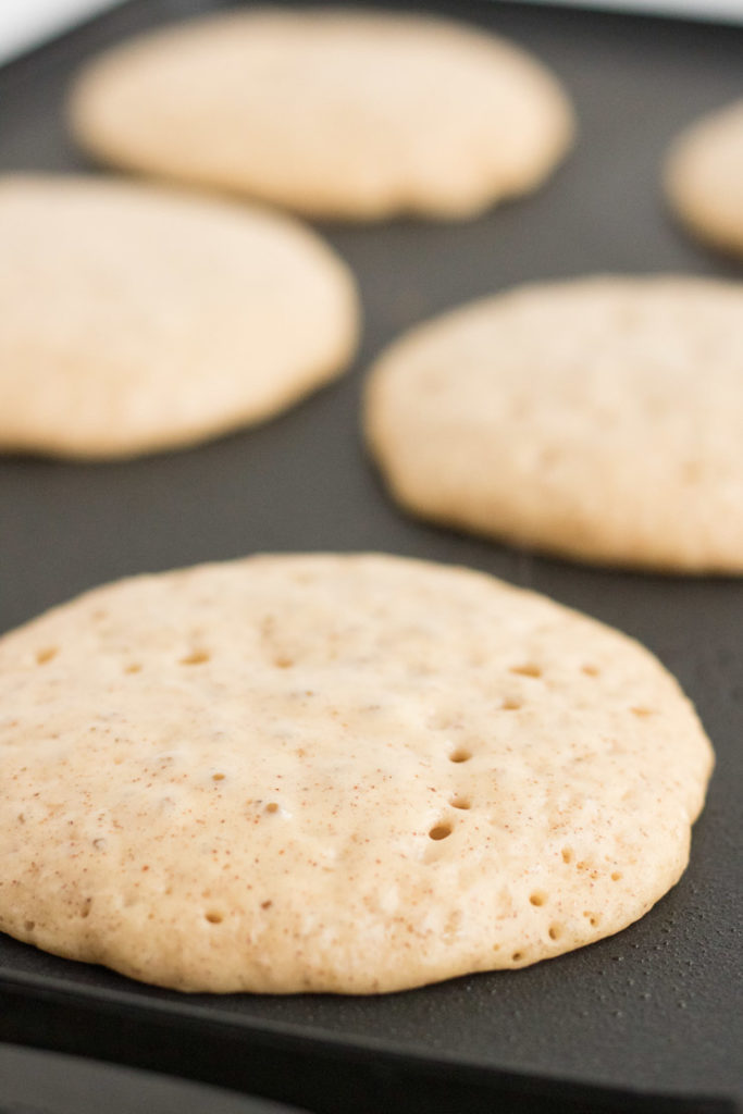 egg nog pancakes being cooked on a griddle