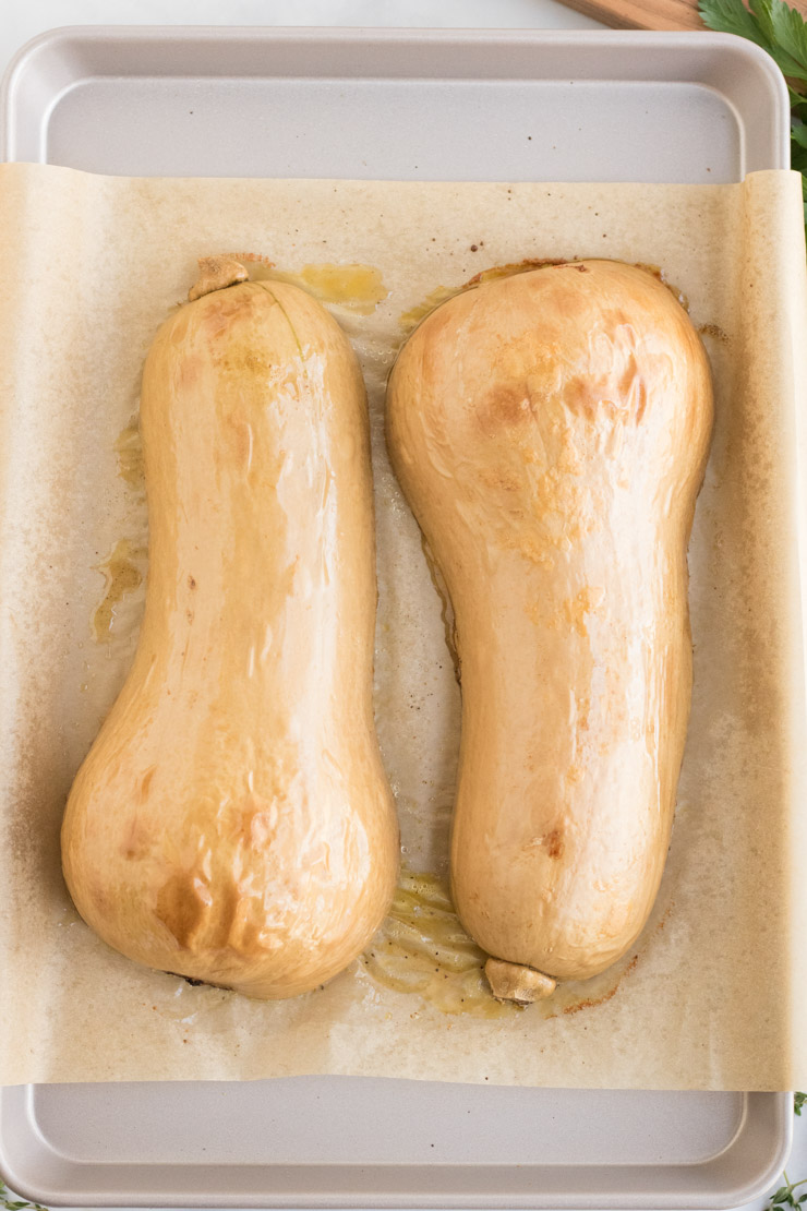 Roasted butternut squash, skin side up on a baking sheet lined with parchment paper. 