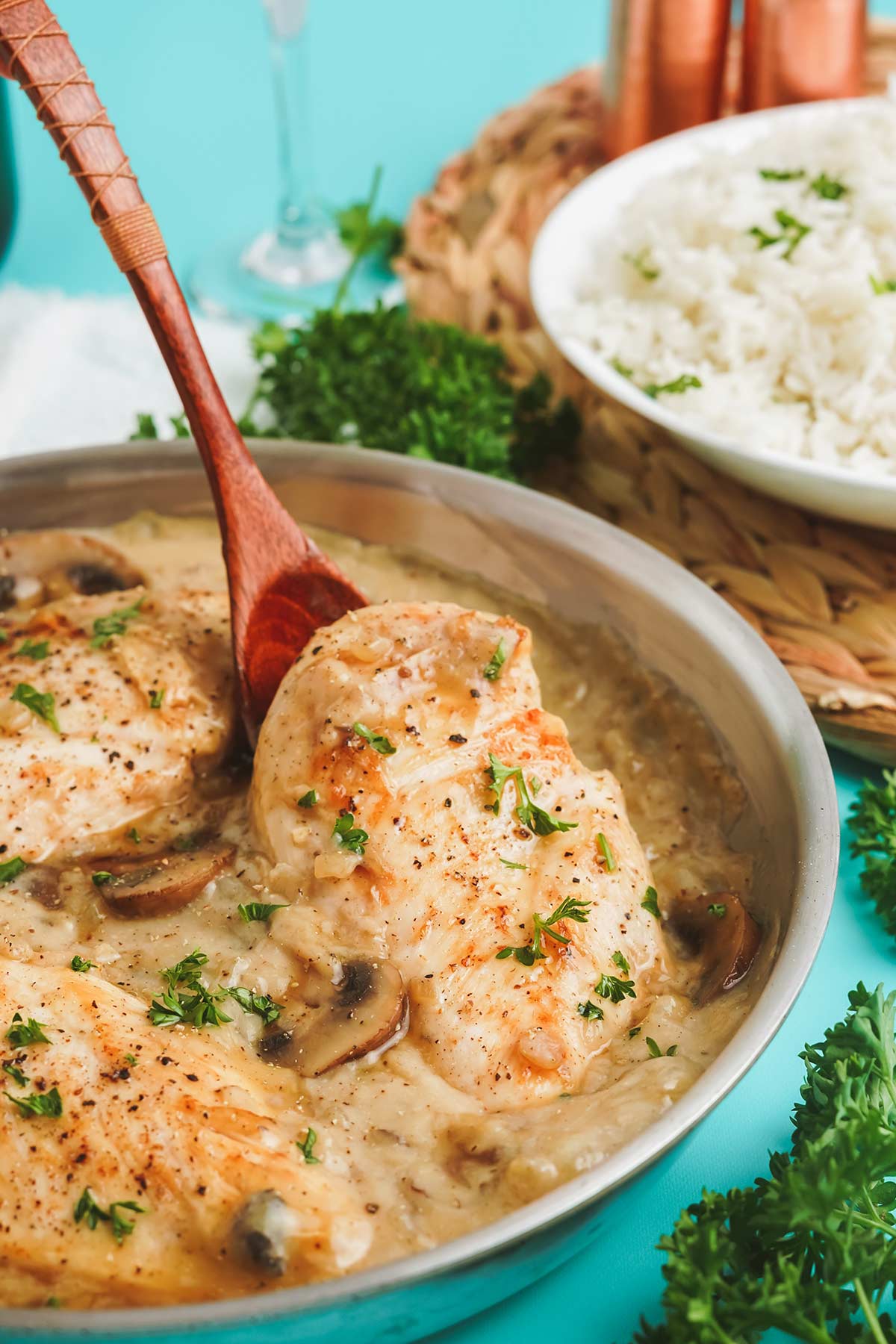 Champagne chicken in the pan with spoon lifting up chicken breast.