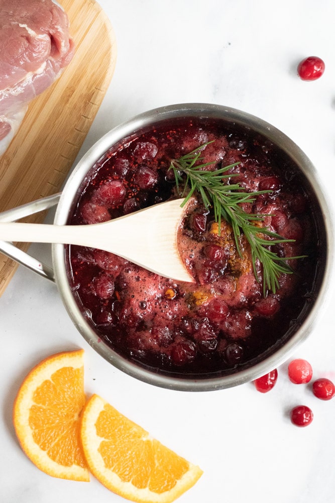 Cranberry Orange Sauce in a small saucepan being made to pour over cranberry orange pork tenderloin. 