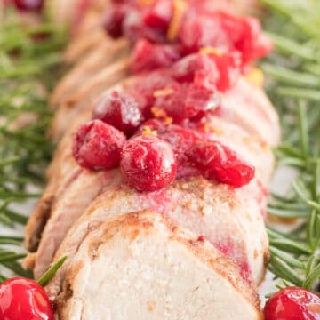 Cranberry Orange Pork Tenderloin, sliced with cranberries on top.