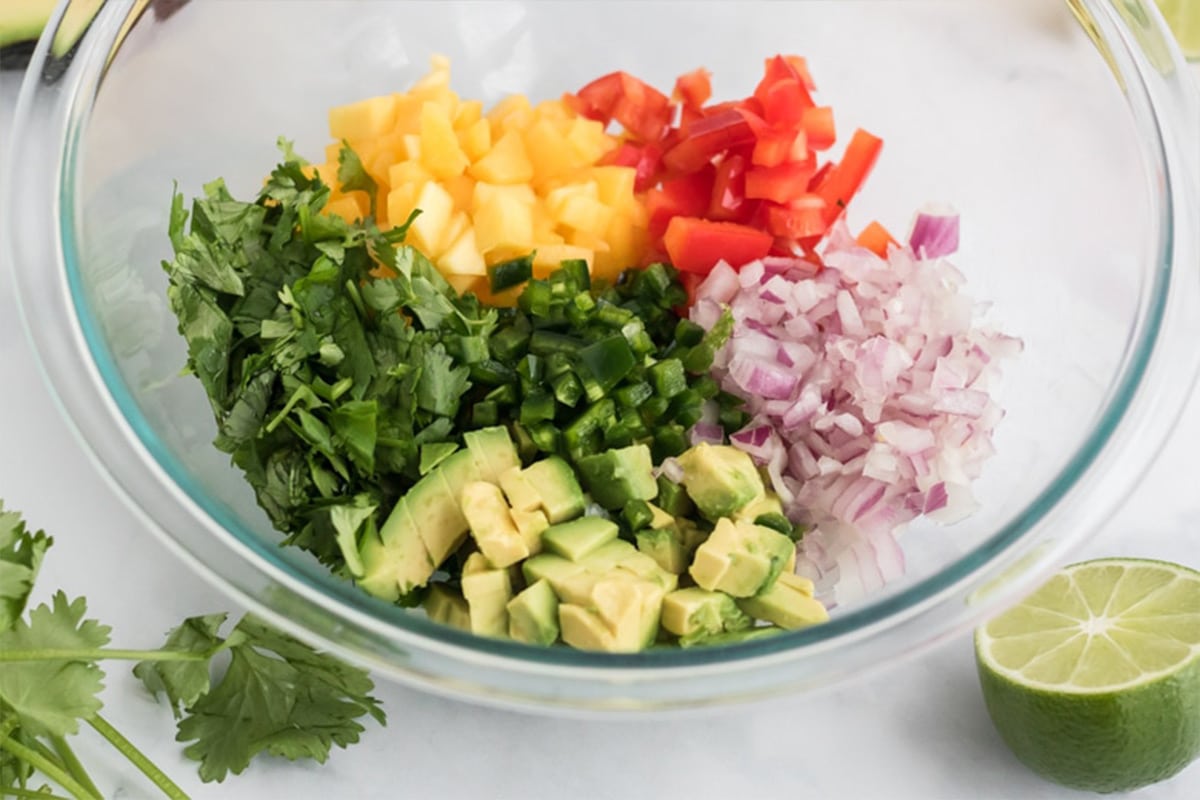 Ingredients to make pico de gallo with mango in a bowl.