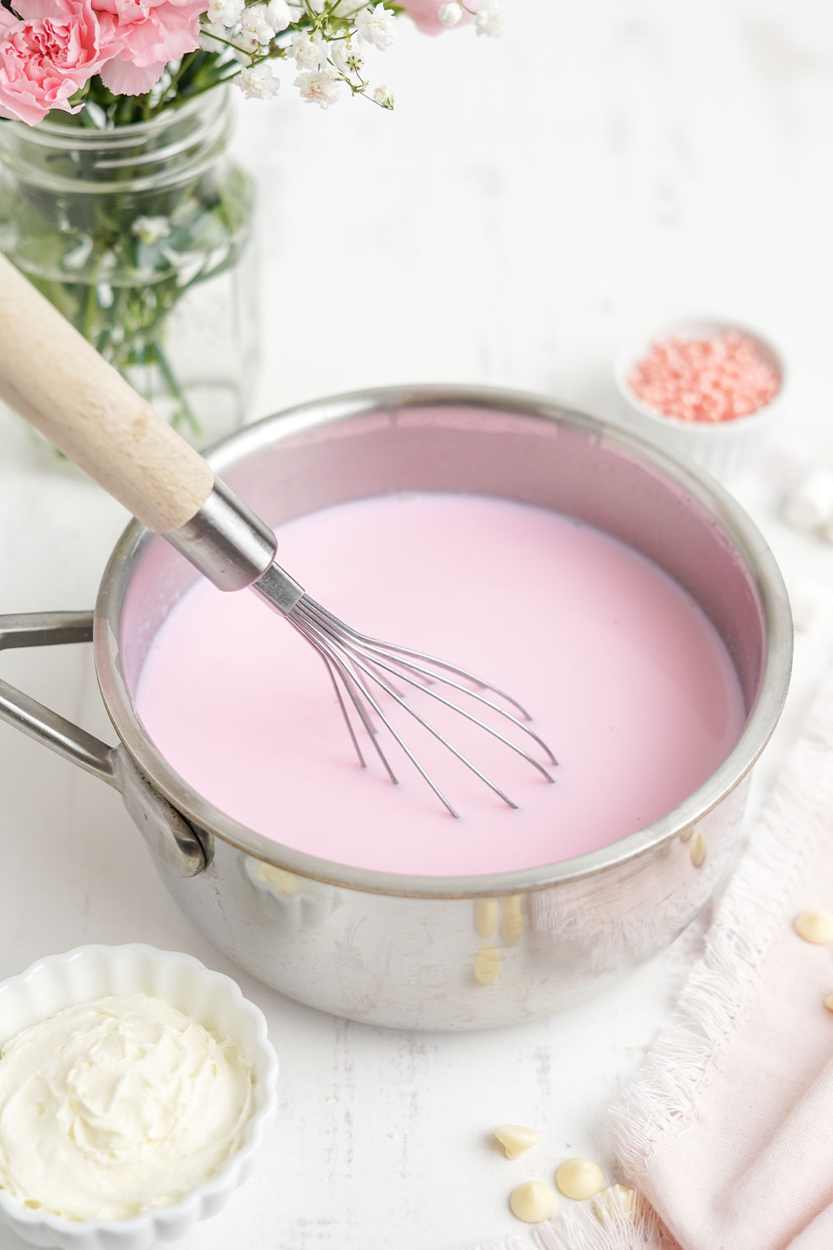 Adding the pink food coloring to the milk.