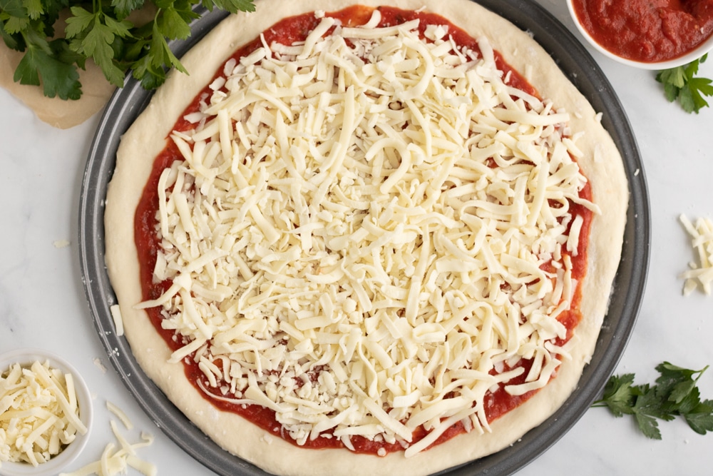 Pizza on a pizza sheet before it is put in the oven. 