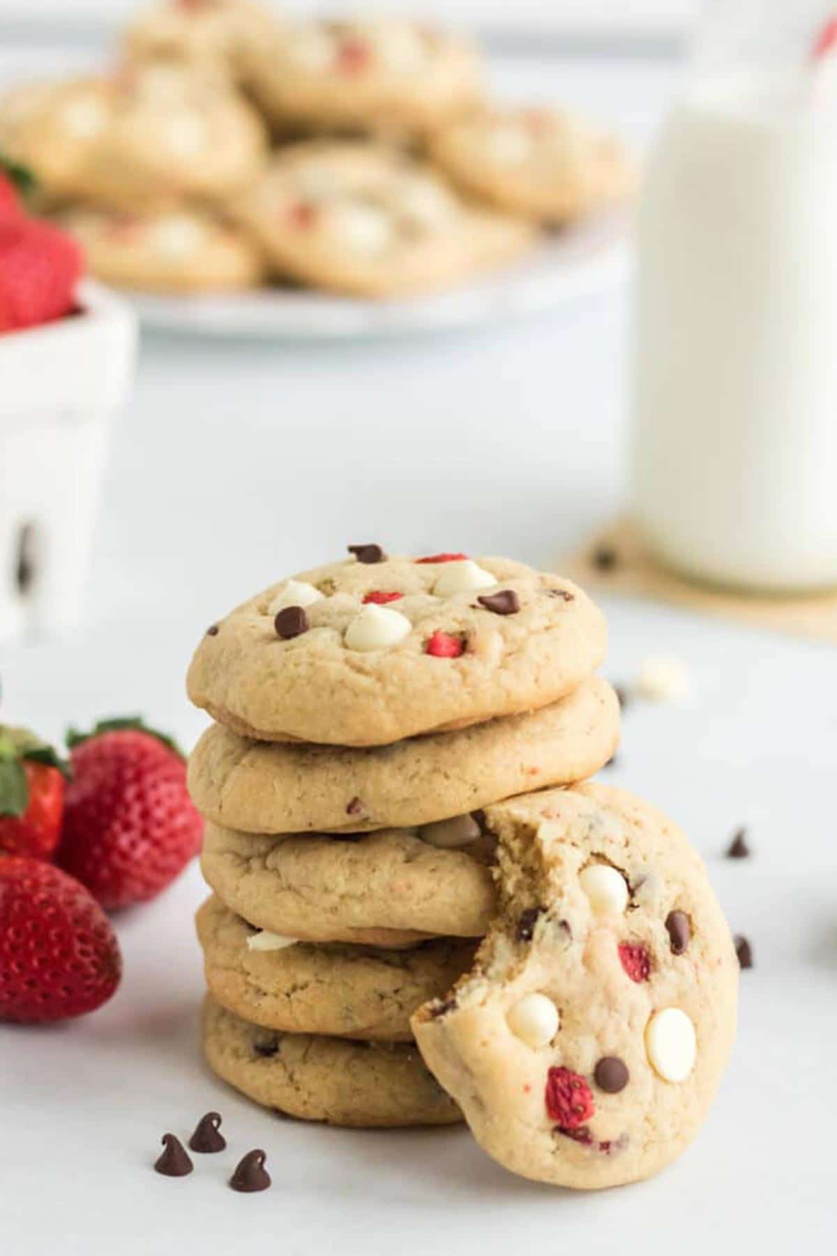 Strawberry Cheesecake Cookies stacked up with white and dark chocolate chips. 