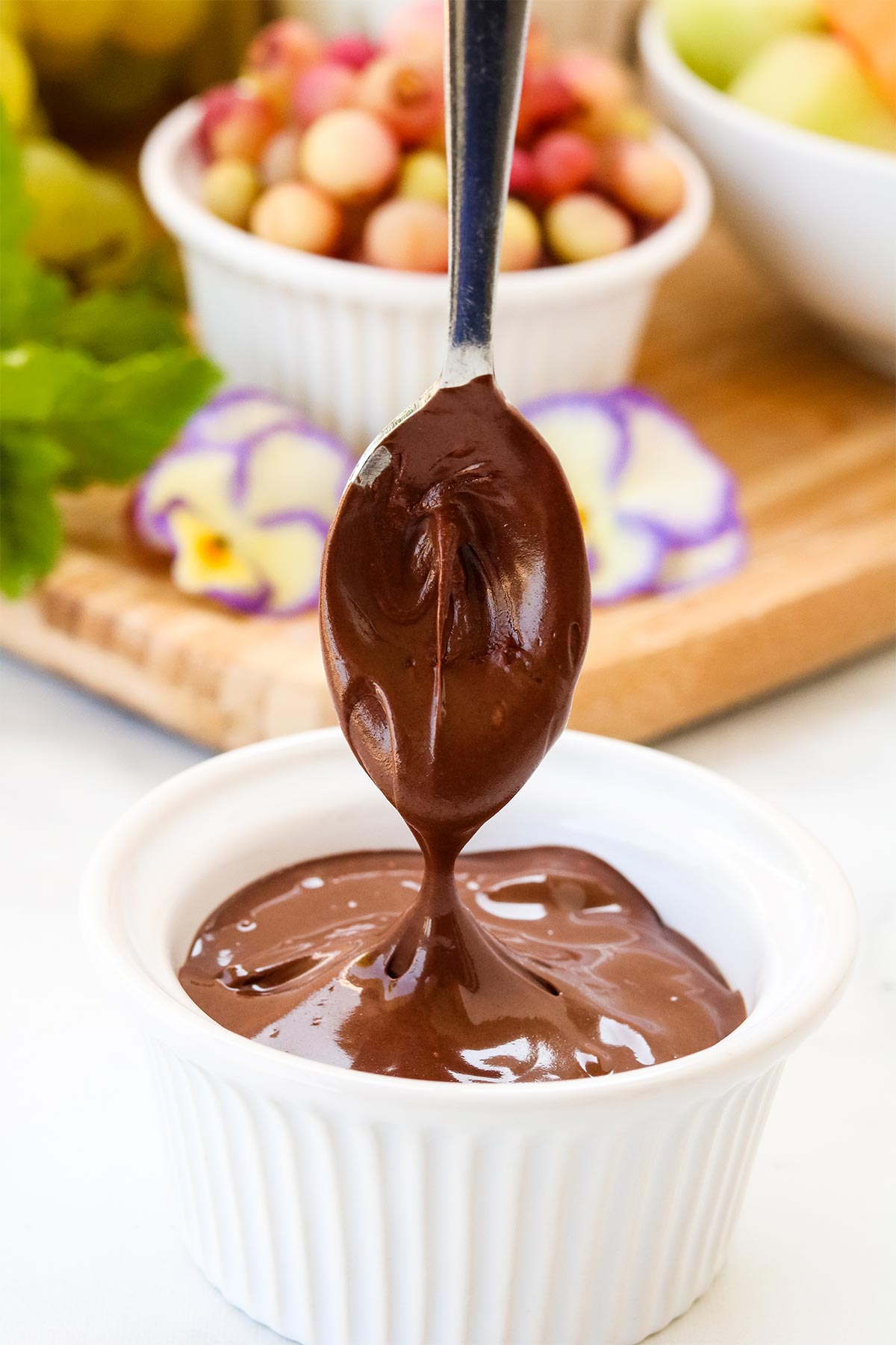 Spoon dipping into melted chocolate.