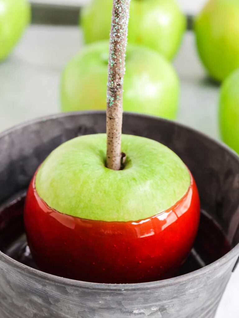 Dipping the apple in the candy coating