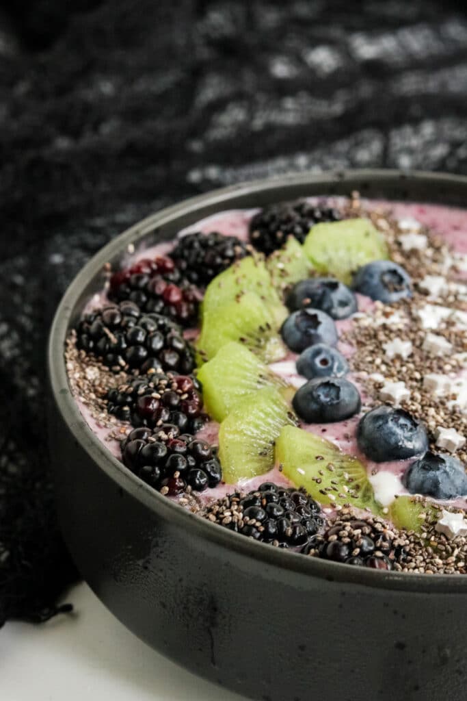 A picture of the side of a Halloween Smoothie Recipe with blackberries, kiwi, blueberries and chia seeds.