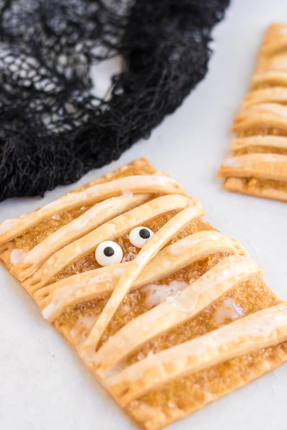 A close up image of an air fryer mummy apple pie tart.
