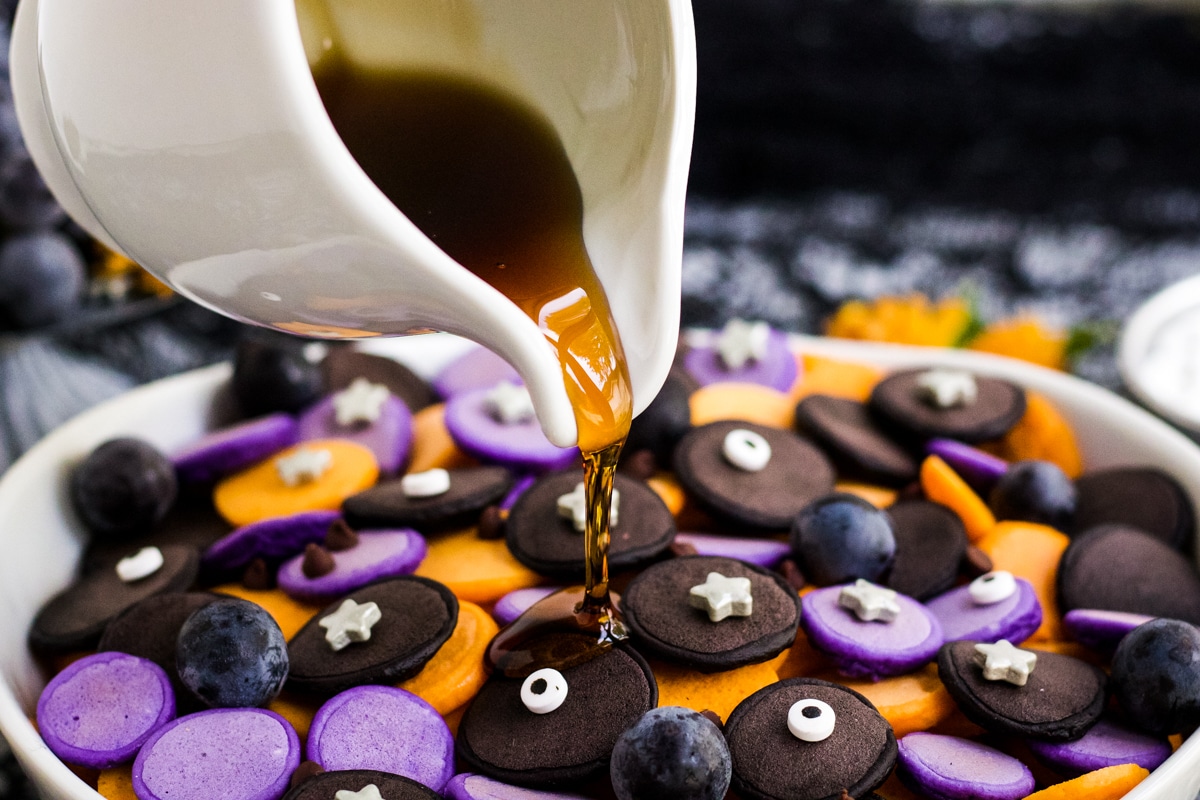 Syrup being poured on Halloween Pancake Cereal. 
