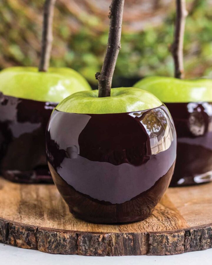 Three poison candy apples on a wood platter