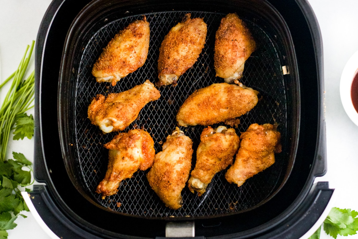 Cooked air fryer chicken wings in the basket ready to serve.