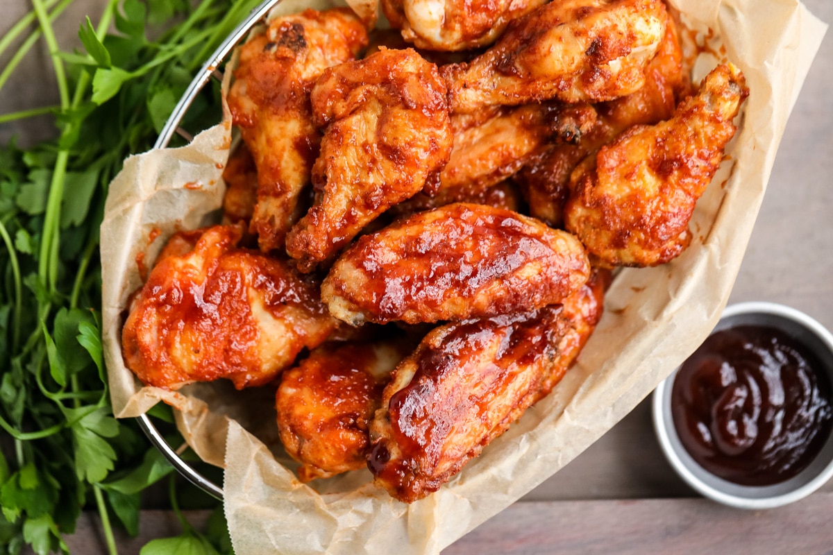 Barbecue chicken wings served up on a table with bbq sauce.