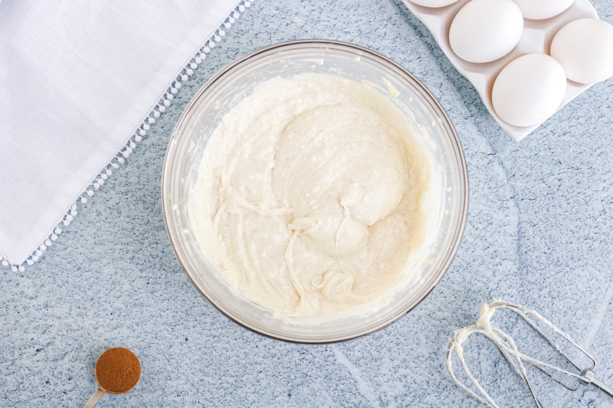 A bowl full of a cream cheese mixture for pumpkin cream cheese pound cake. 