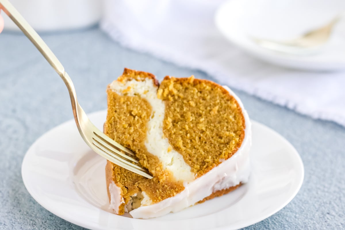 Cream Cheese Pumpkin Pound cake on a white plate with a fork going in for a bite.