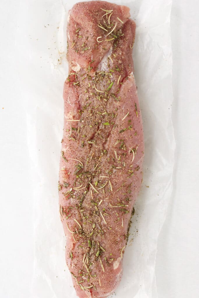 Pork tenderloin with meat rub spread all over it.
