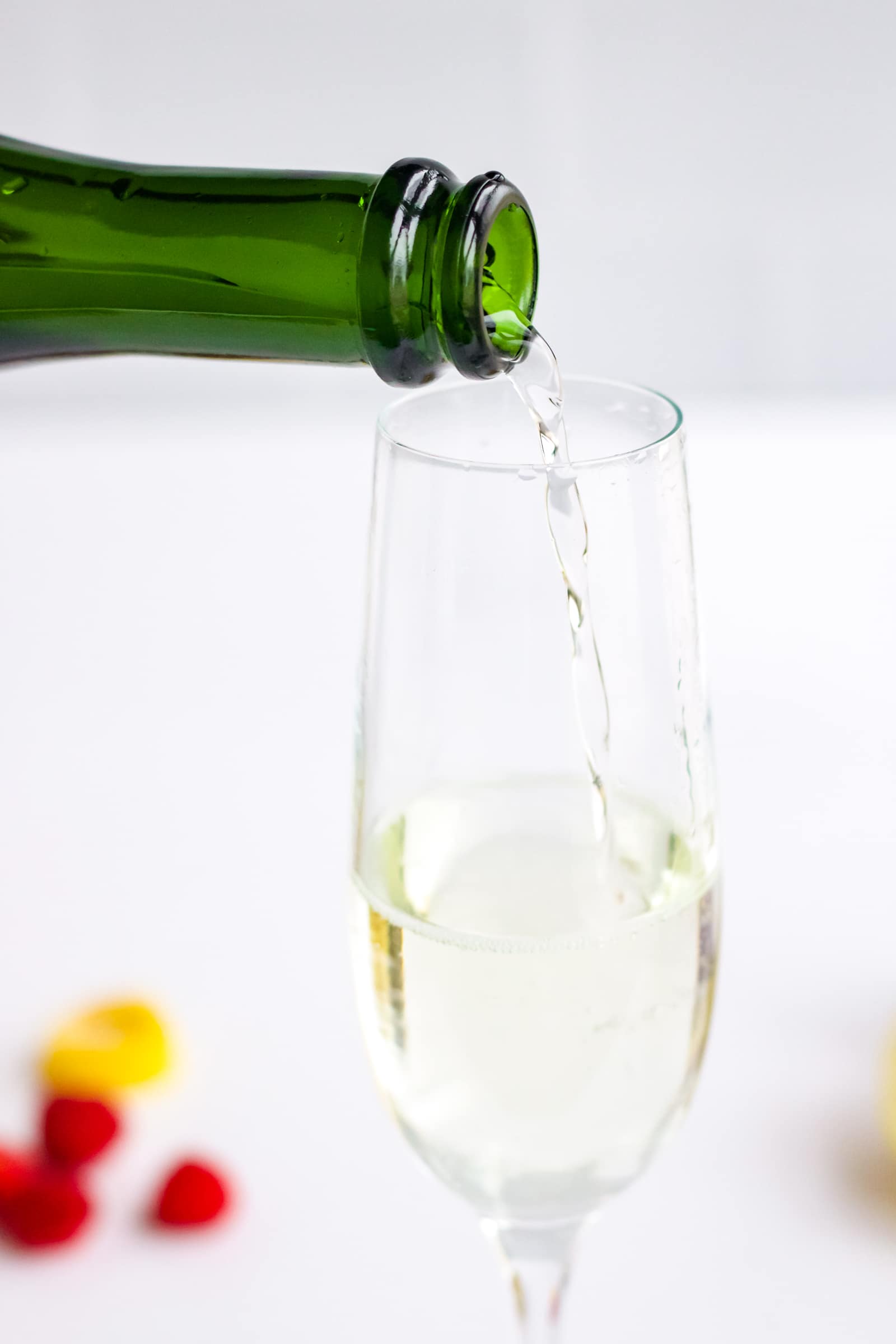 Champagne being poured into a champagne flute to make a Chambord and Champagne cocktail. 