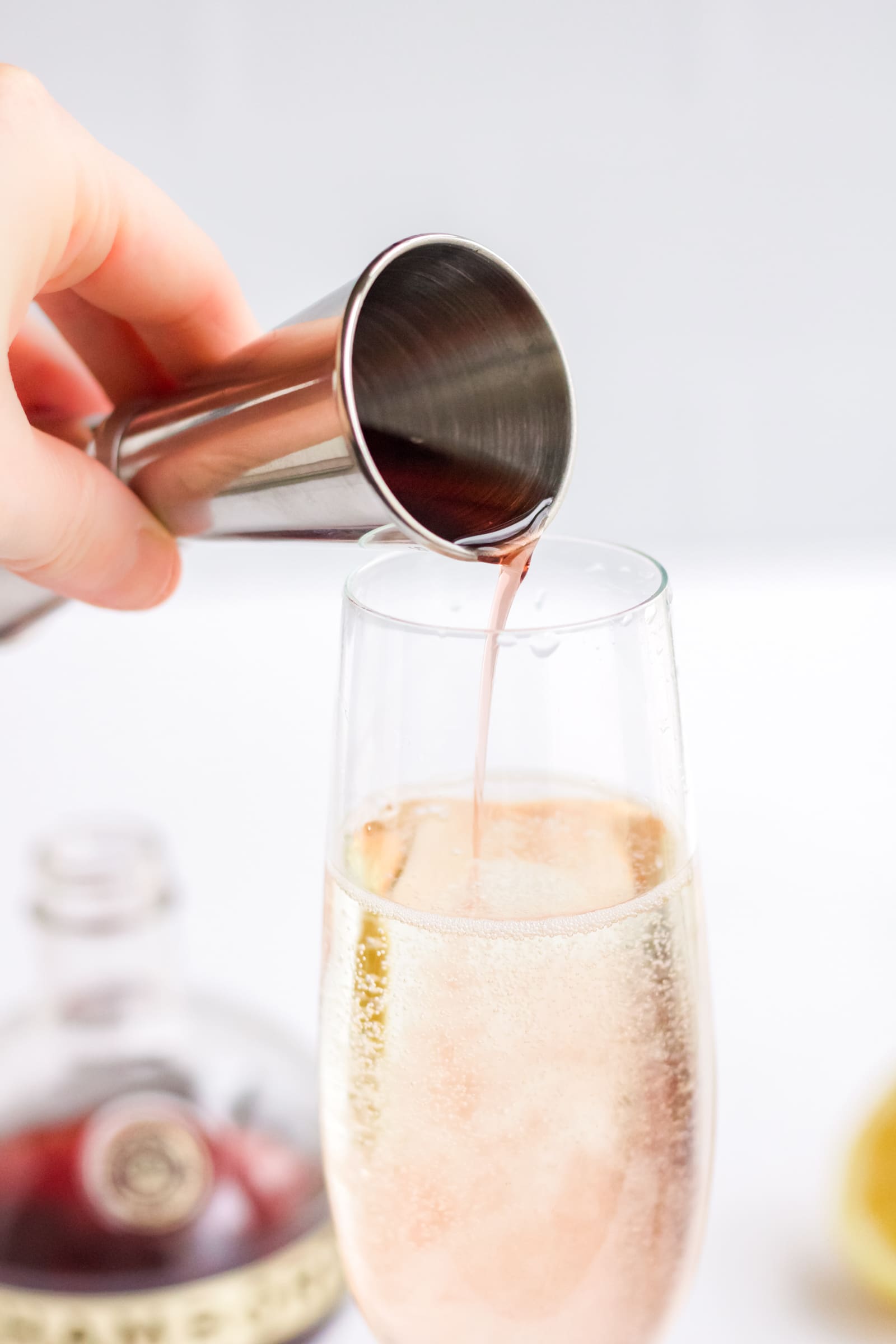 Chambord being poured into a Champagne flute to make a simple Champagne and Chambord cocktail. 