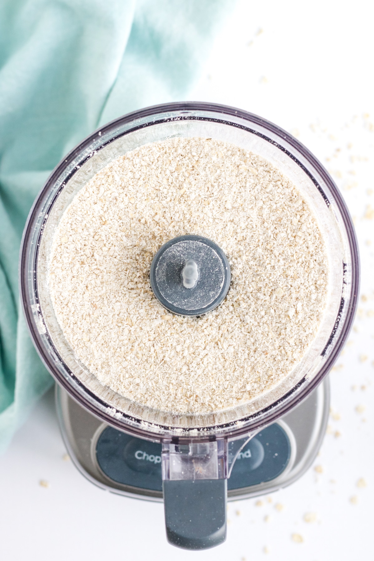 An overhead image of ground oats in a food processor to make oat flour. 