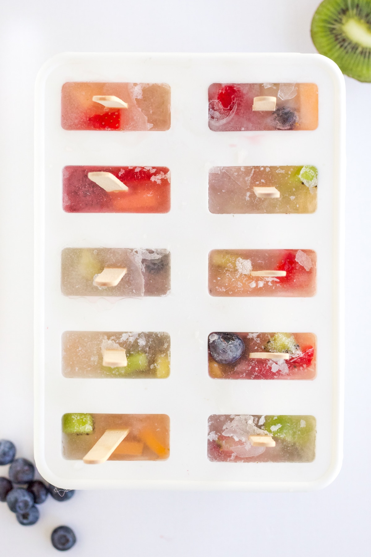 overhead shot of frozen fruit popsicles still in mold