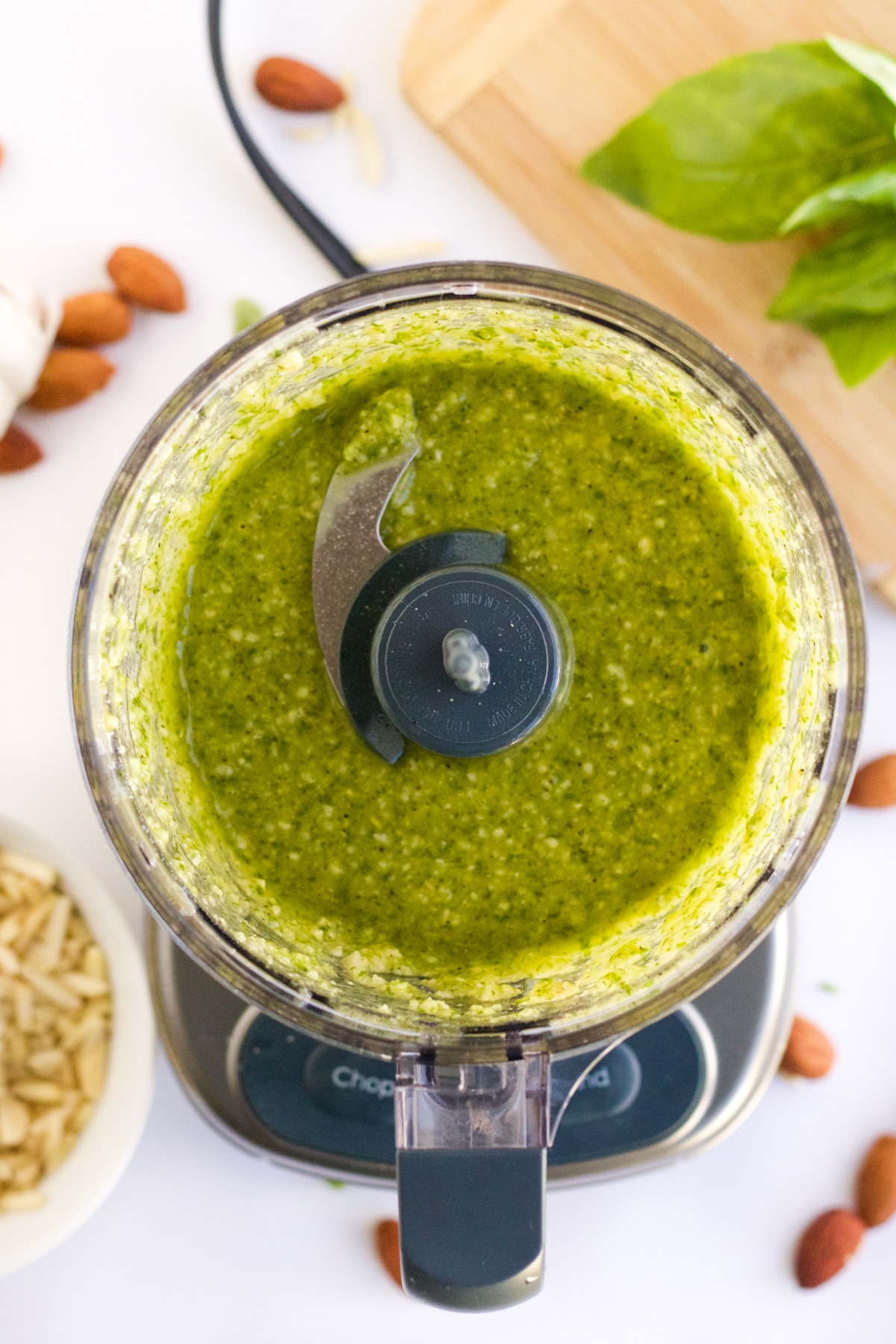 An overhead image of almond pesto in a food processor after blending. 