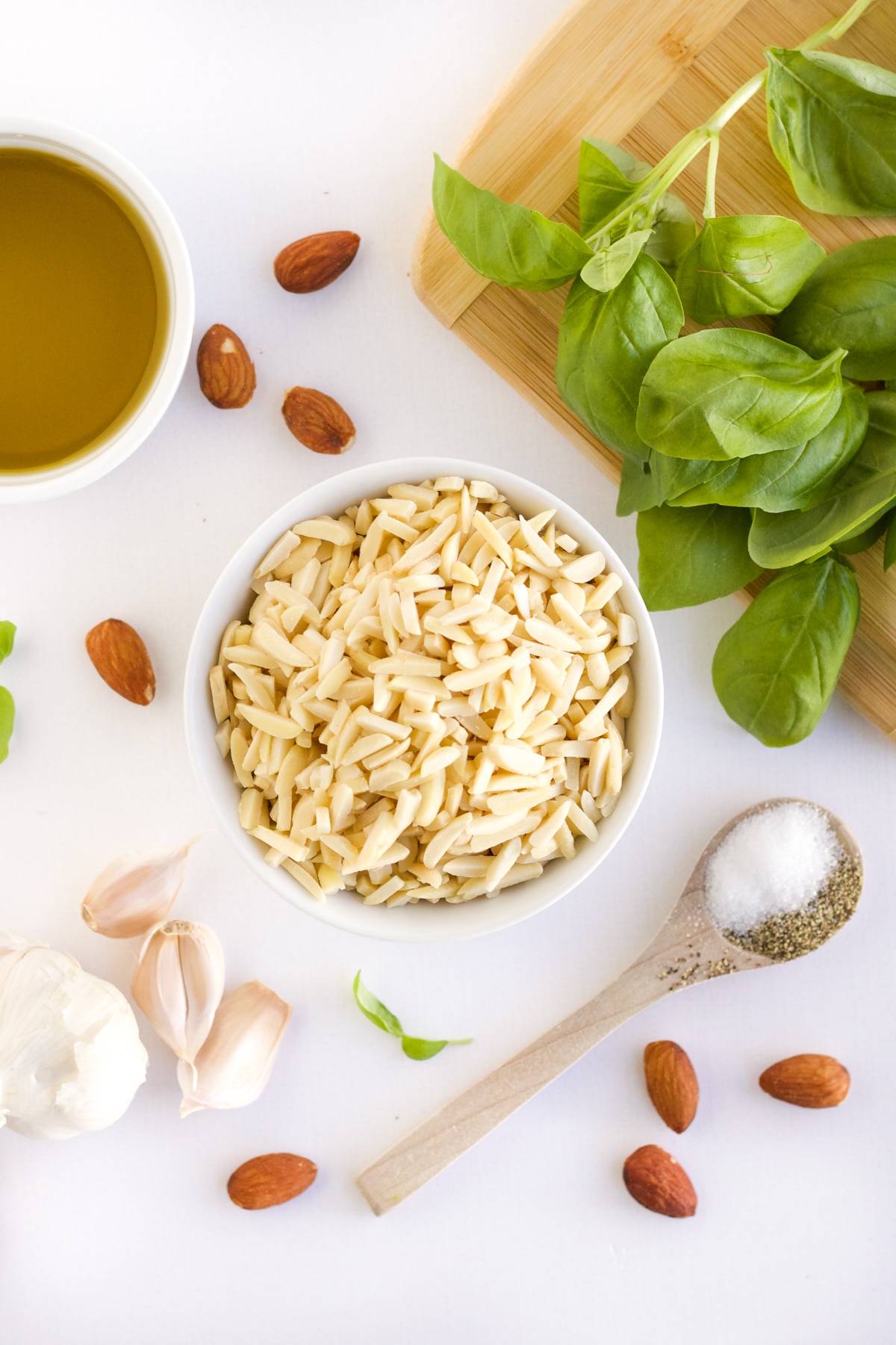 Ingredients for homemade almond pesto - slivered almonds, olive oil, fresh basil, garlic and salt and pepper