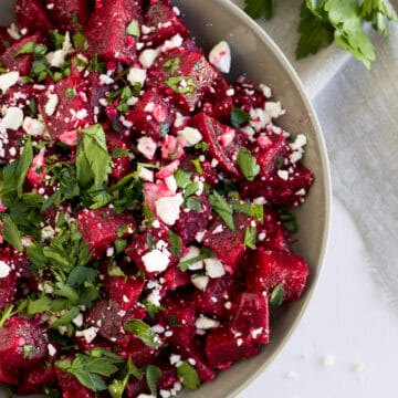 An overhead image of a beetroot salad in a grey bowl.