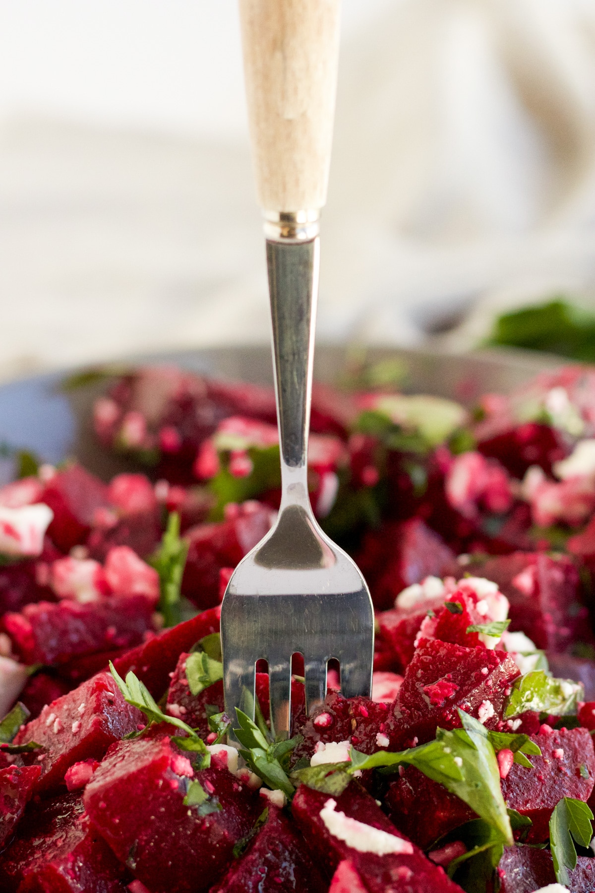 A fork scooping up a bite of beetroot salad. 