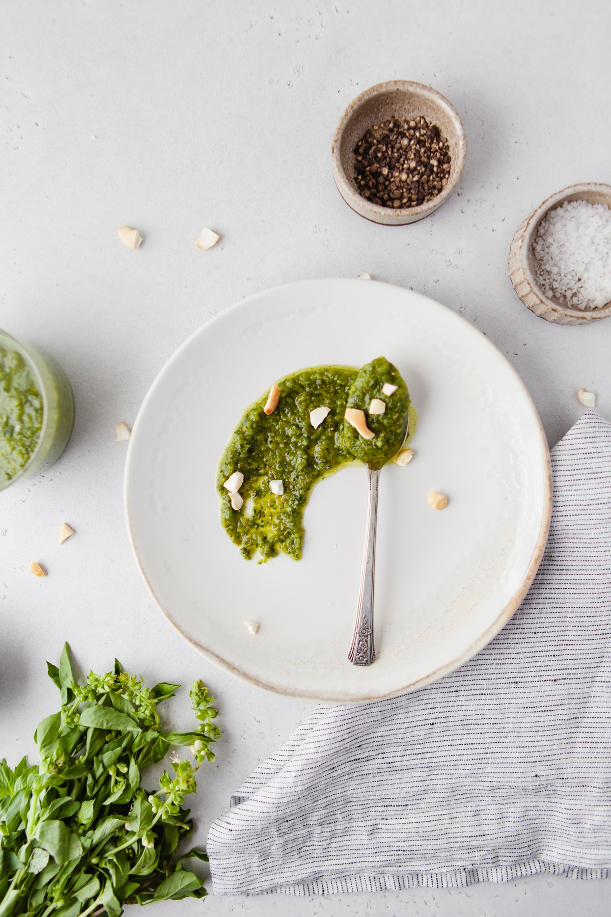 An image of homemade cashew pesto sauce smeared on a white plate to make copycat Trader Joe's Black Truffle Pesto Sauce. 