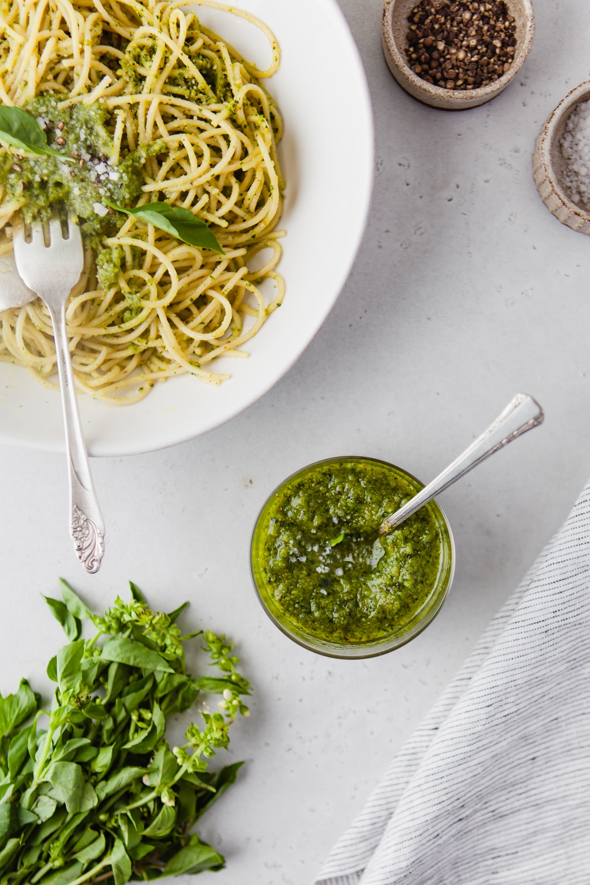 bowl of cashew pesto and white bowl with pasta dressed with pesto