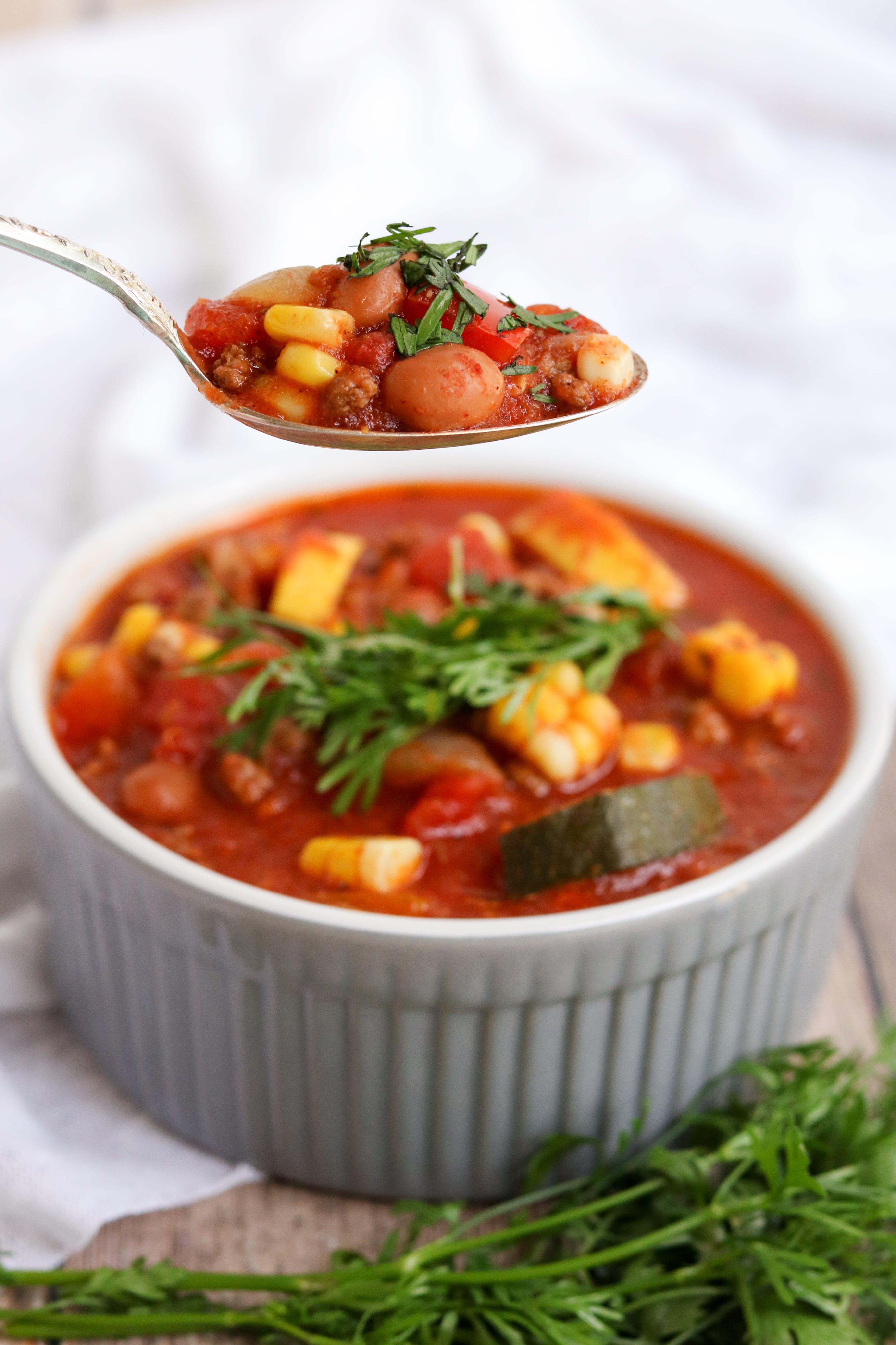 summer chili in a white crock with a spoon