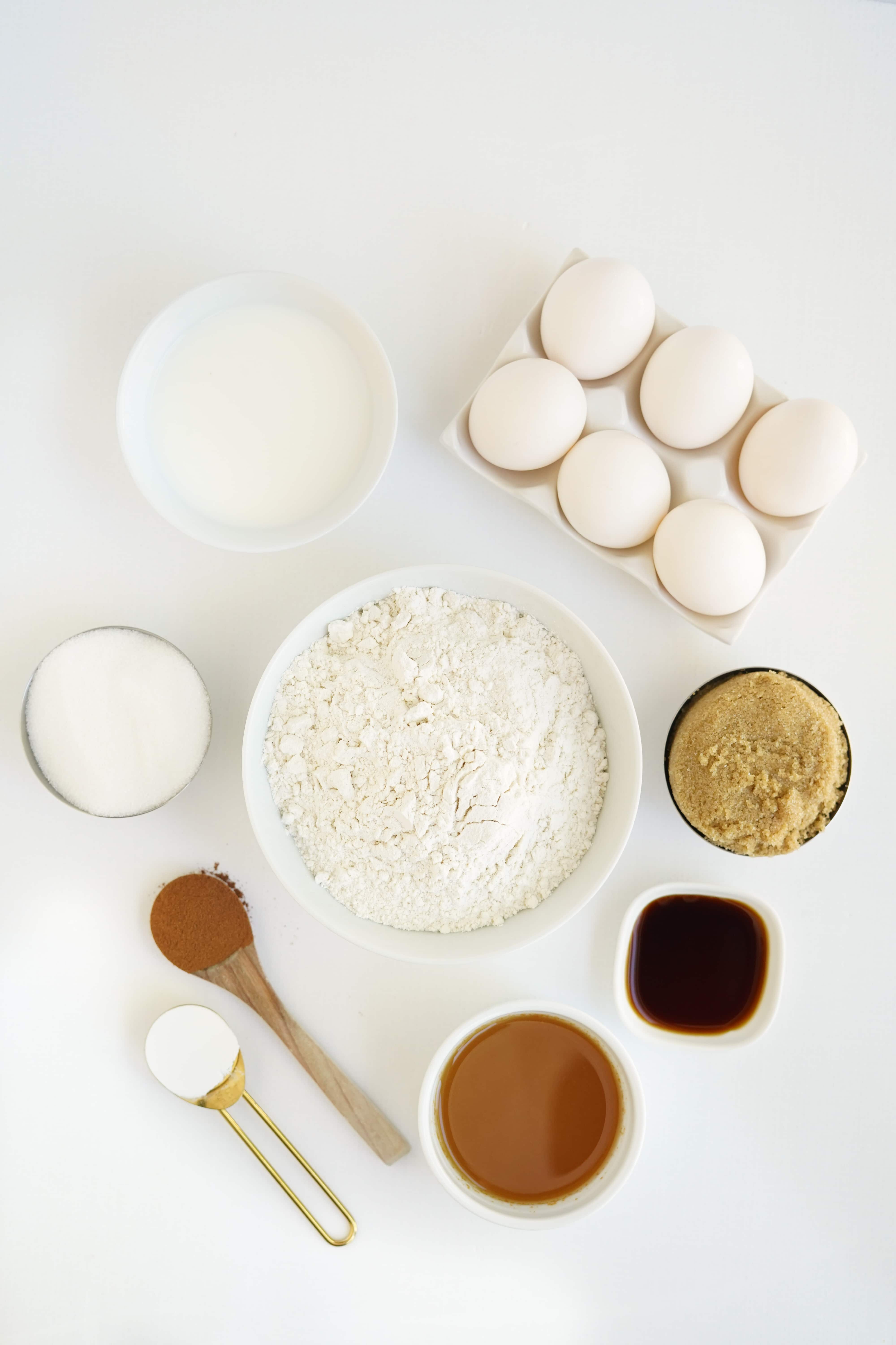 bowls of flour, milk, sugar, apple cider, ground cinnamon, baking soda, and eggs