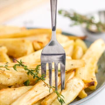 fork in a plate of parsnips with thyme