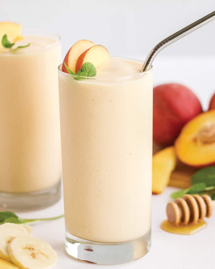 Two glasses of banana peach smoothie on the table.