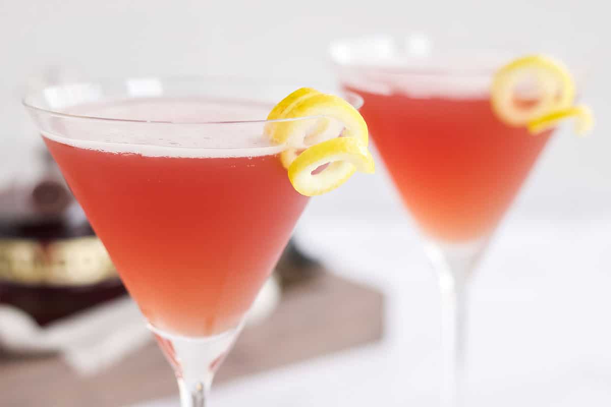 Close up of two glasses of french martinis on the table with a lemon twist on the glass.