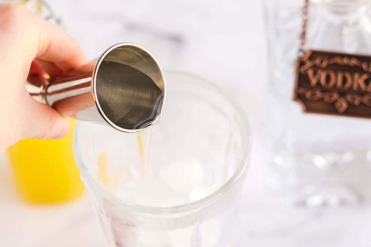 Pouring the vodka into the glass.