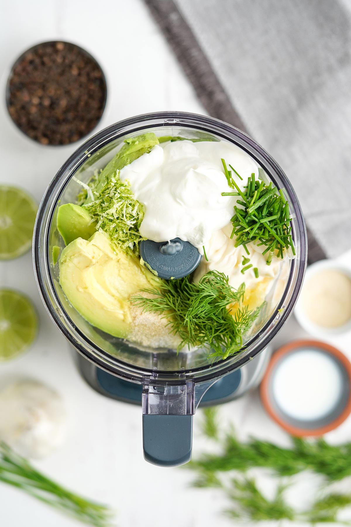 All the ingredients to make avocado lime ranch dressing in a food processor to mix.