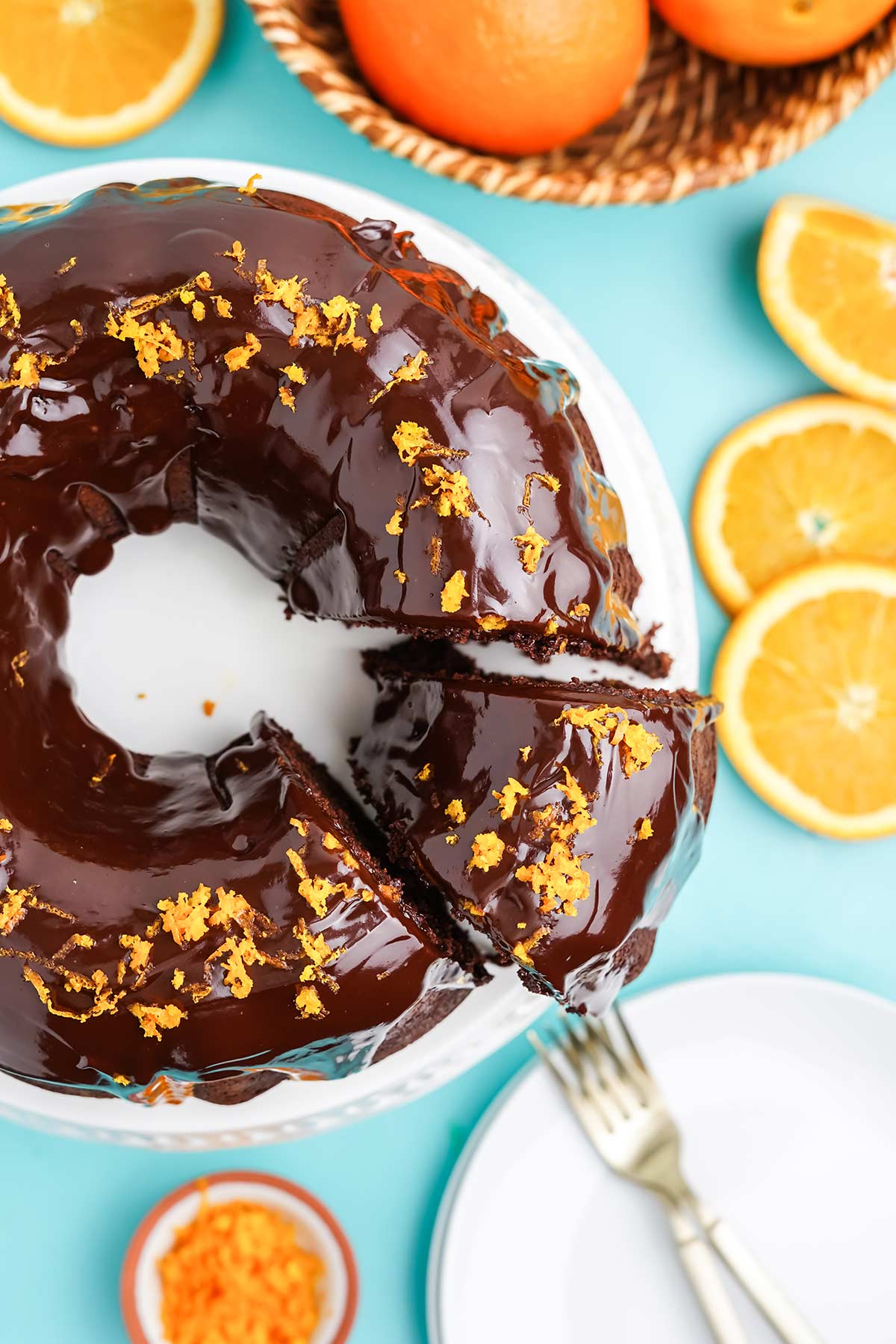 Chocolate and orange cake on the table with a slice cut and slightly pulled out from cake.