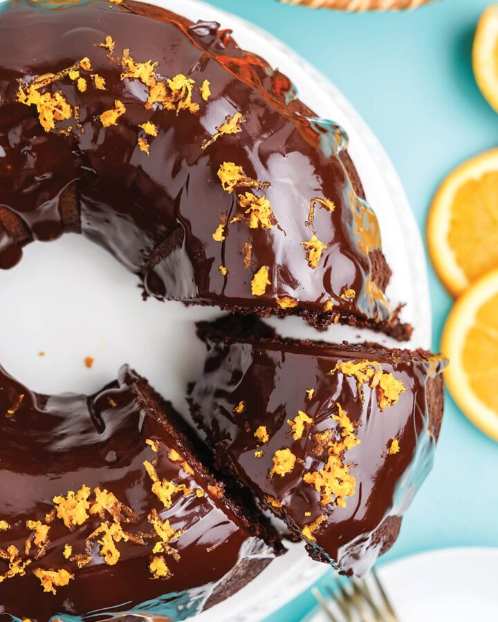Chocolate orange bundt cake on the table with a piece cut and being served.