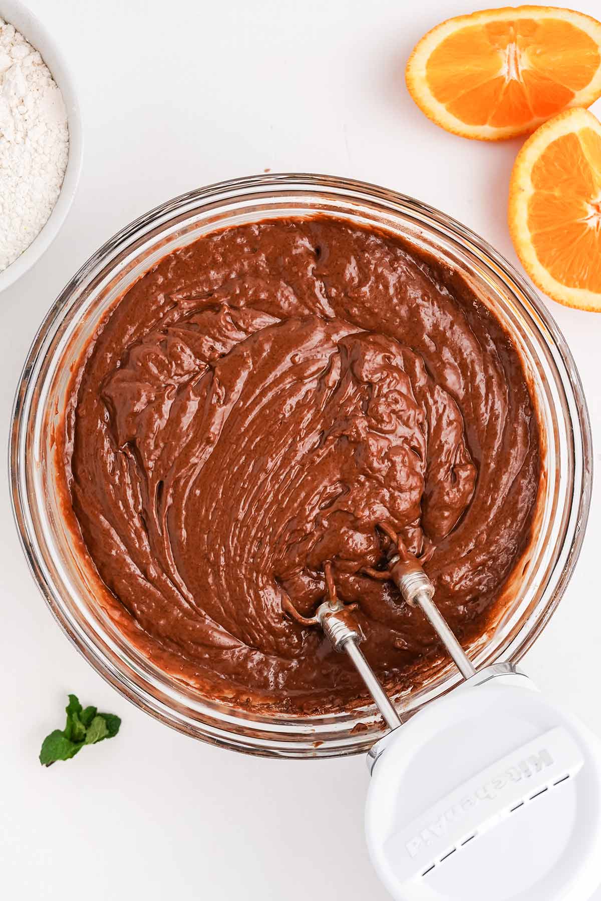 Using a hand mixer to make the batter for a chocolate orange cake recipe.