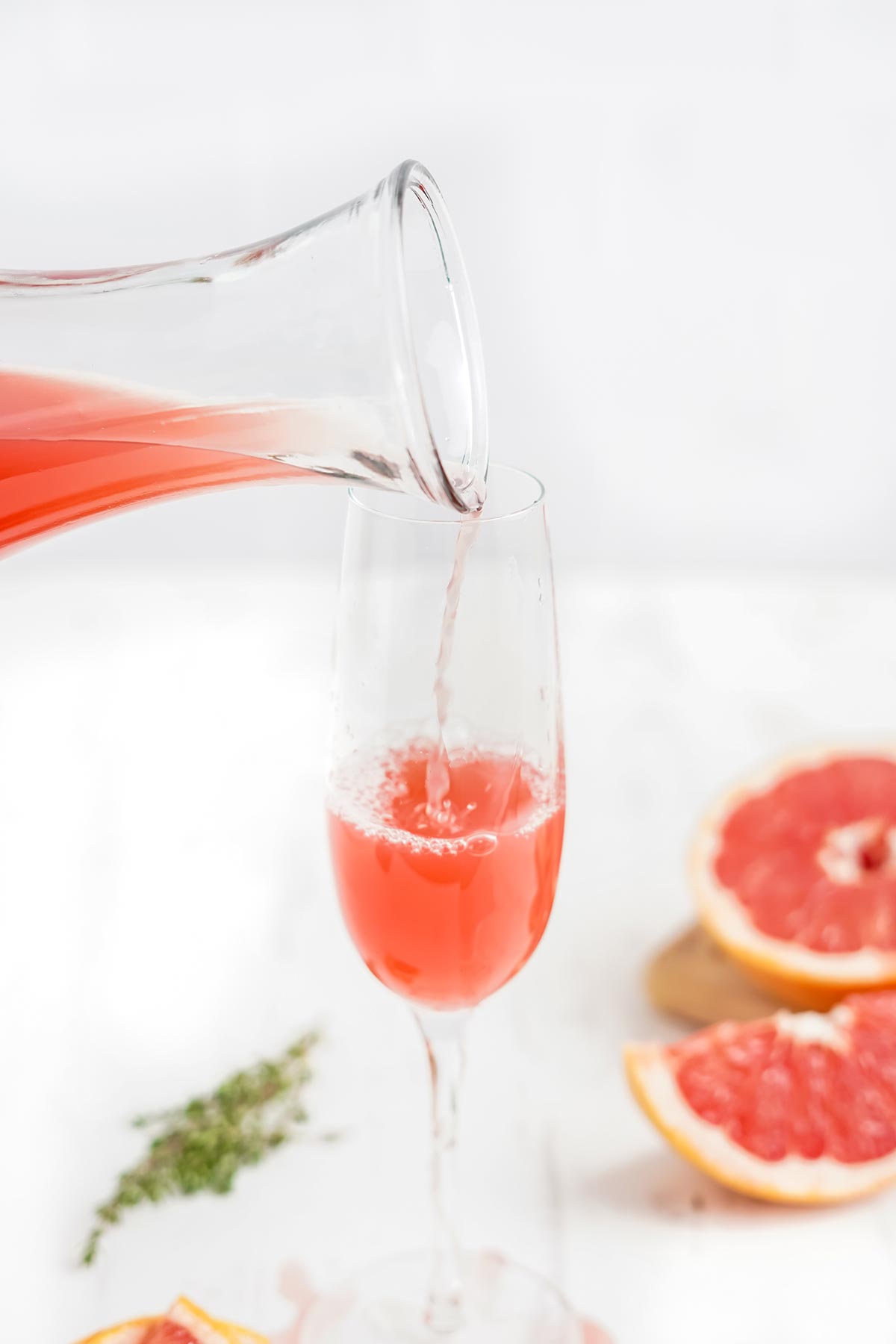 Pouring the grapefruit juice into the glass to make a mimosa.