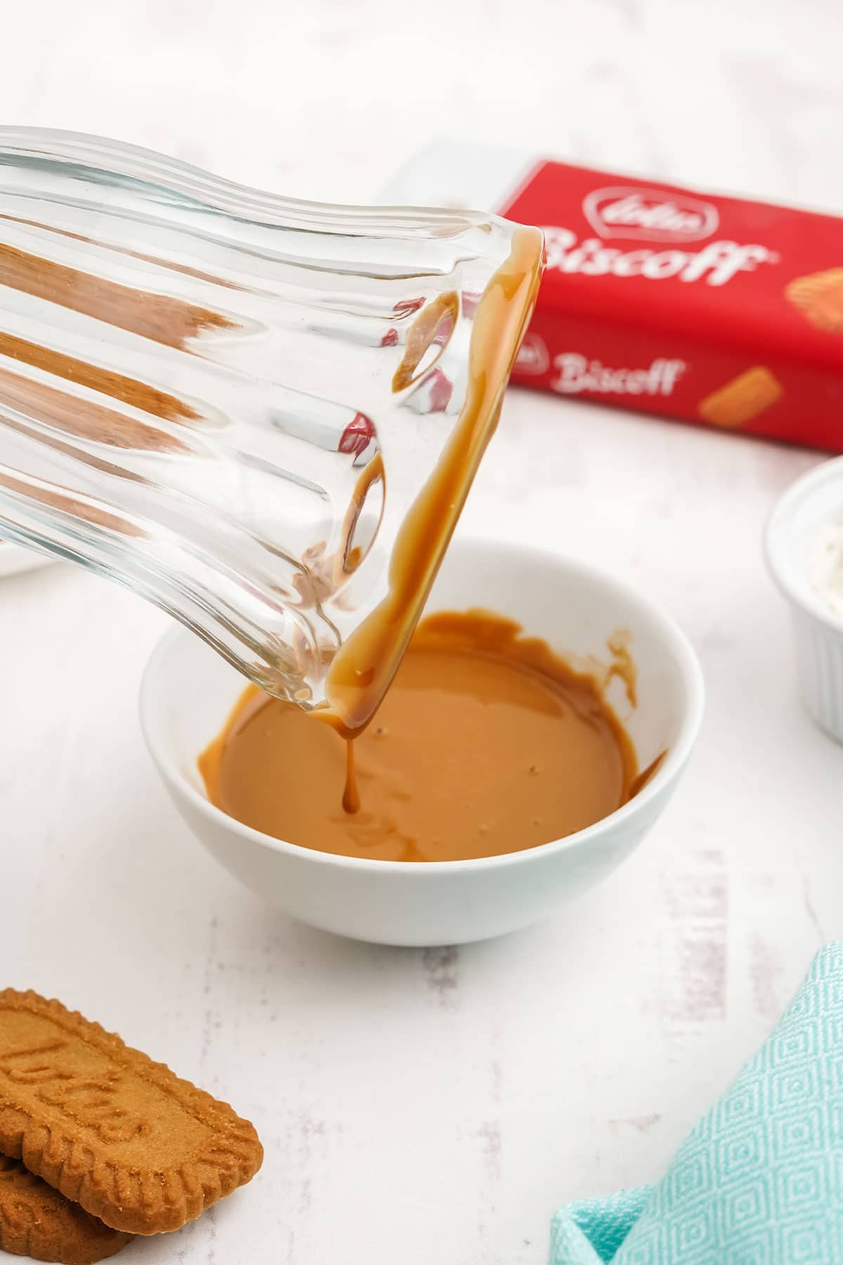 Dipping glass in caramel sauce so cookies stick.