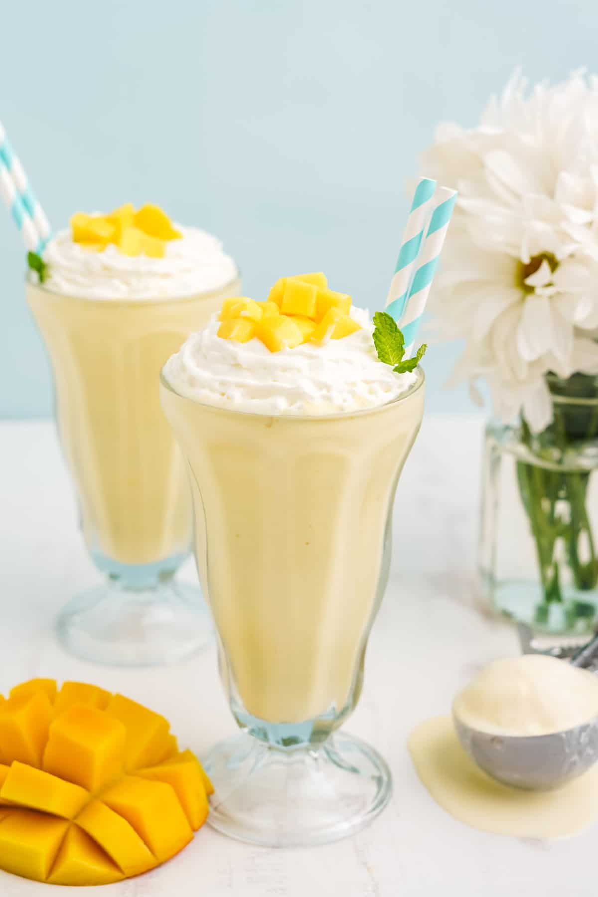 Two old fashioned glasses with mango milkshake.