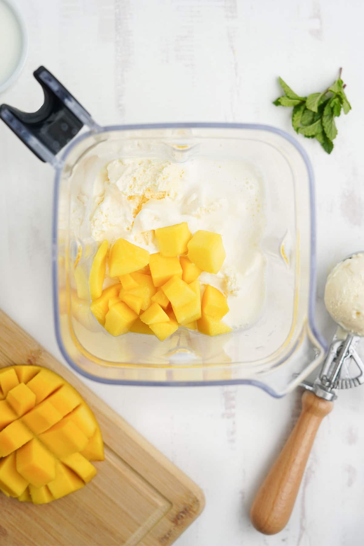 Ingredients for a mango shake in the blender.